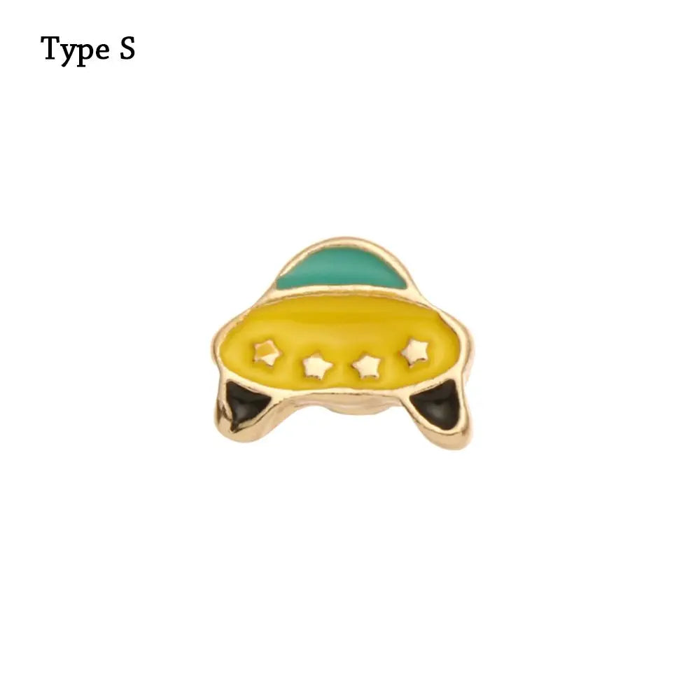 Adorno de pulsera de metal decorativa con forma de fruta amarilla y parte superior verde.