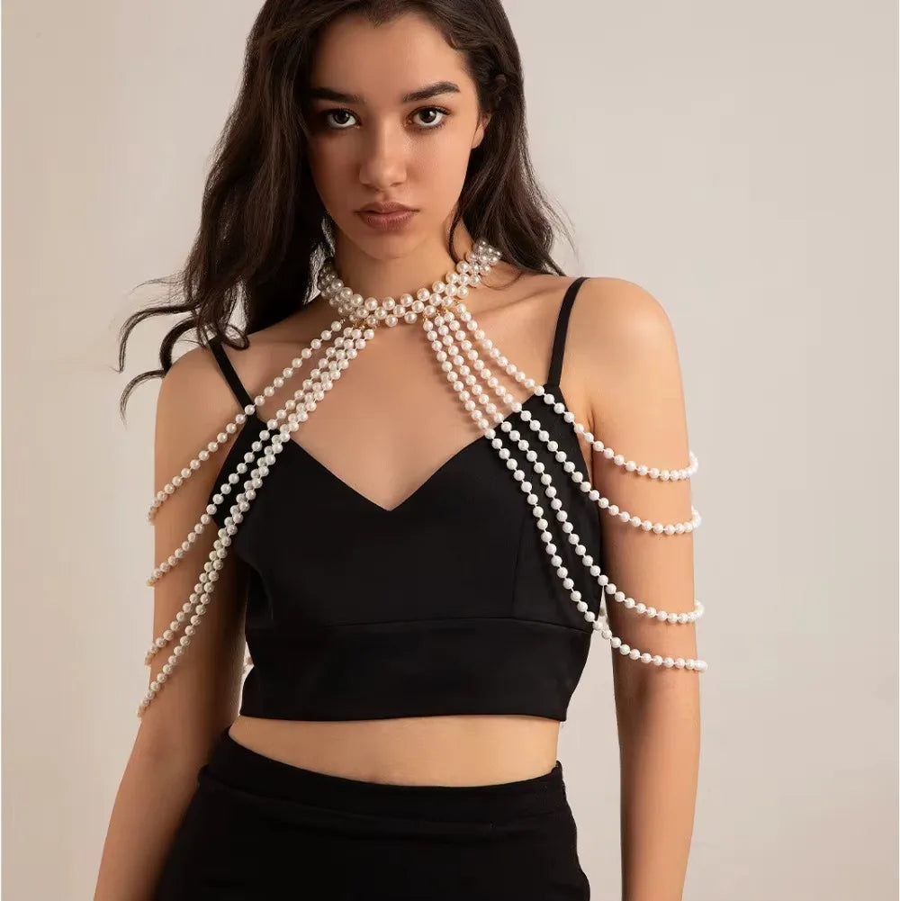 A woman models a black crop top and skirt with an imitation pearl statement necklace set