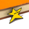 A yellow star enamel pin with the text your did it on a leather-bound book.