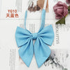 A light blue solid cotton bow tie shown against a white background with floral and natural elements.