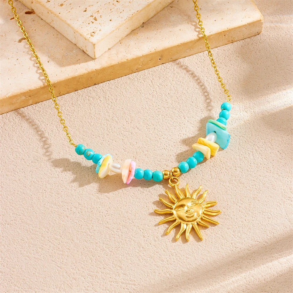 Gold chain necklace featuring a starfish heart pendant with colorful beads on a light background.