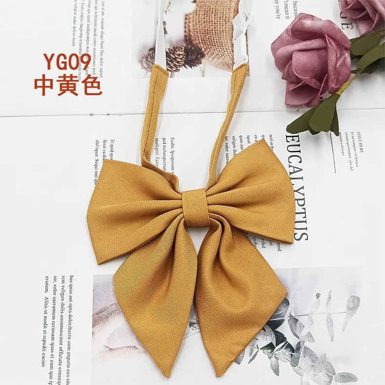 A solid mustard yellow cotton bow tie tied in a bow, displayed against a white background.
