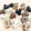 A collection of 12 rectangular hair clips in various shades of brown, beige, and black.