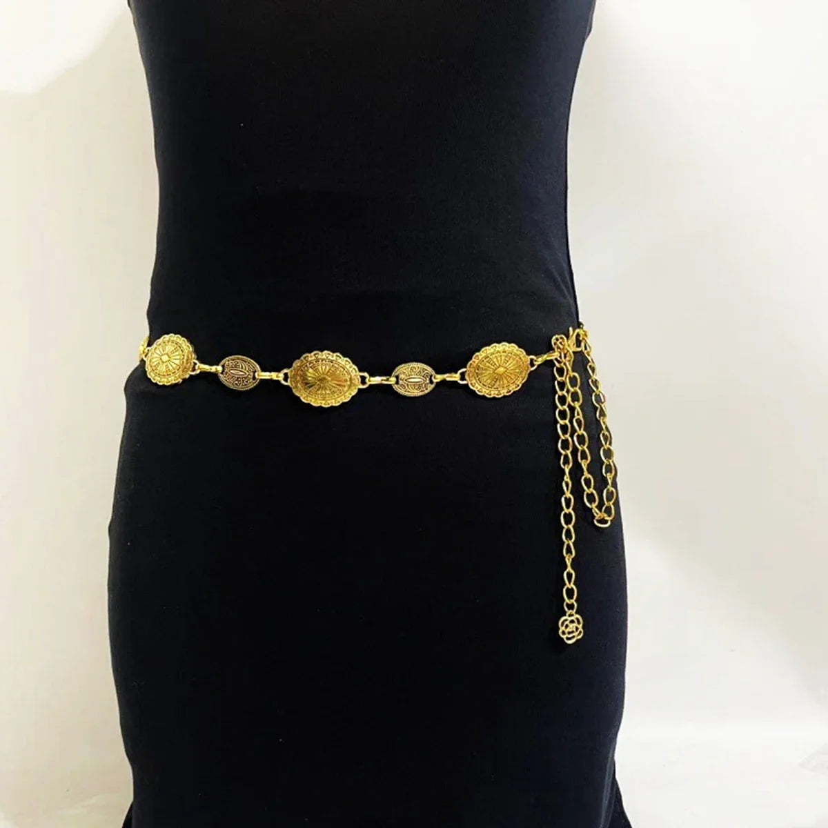 Cadena de cintura ovalada de metal dorado vintage para mujer, mostrada sobre fondo negro.