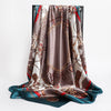 A draped silk shawl featuring an intricate brown, gold, and teal floral pattern.
