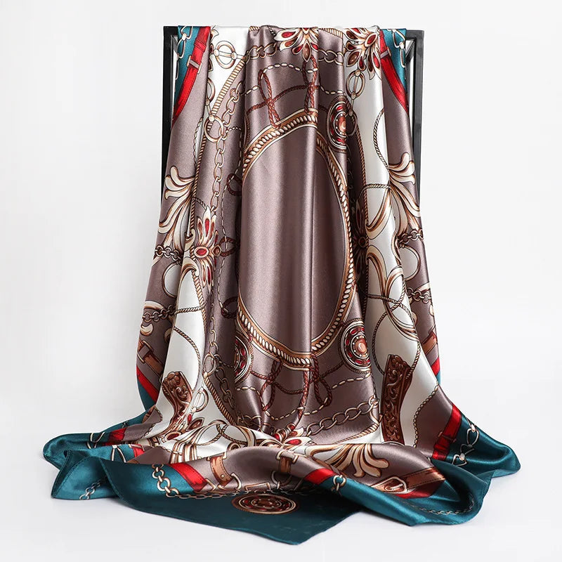 A draped silk shawl featuring an intricate brown, gold, and teal floral pattern.