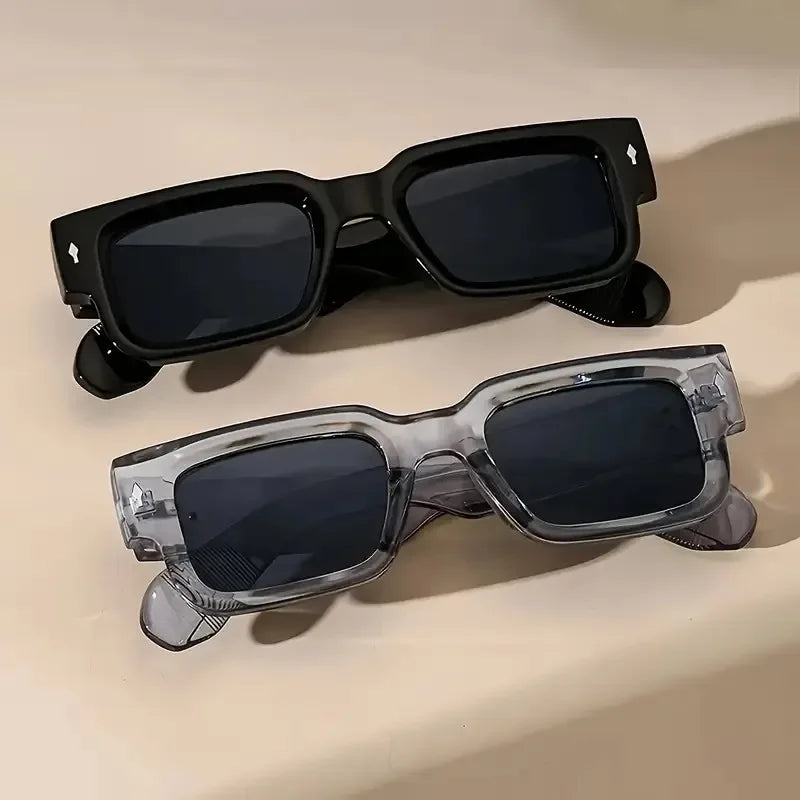 Eine schwarze, quadratische Sonnenbrille liegt auf einer hellen Oberfläche.