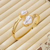 A gold ring featuring a baroque imitation pearl set in a light beige velvet box.