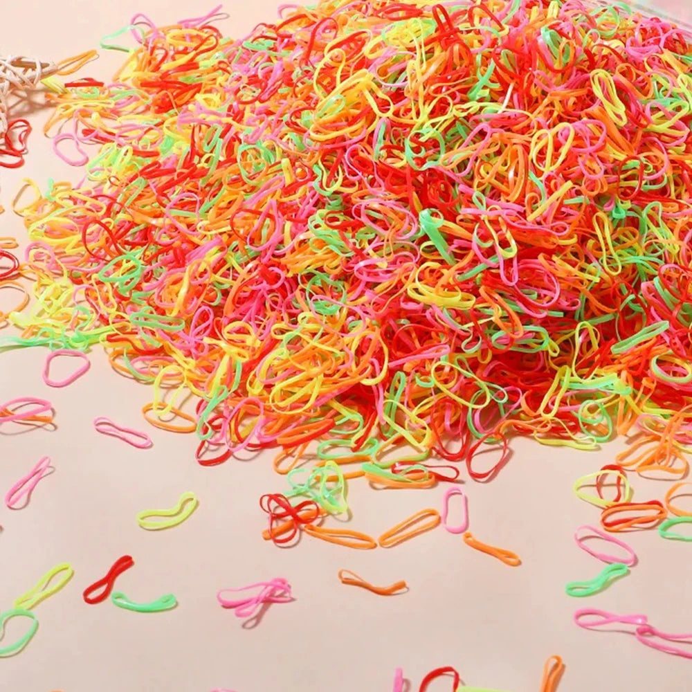 A pile of colorful disposable rubber hair ties in various shades of pink, orange, and green.