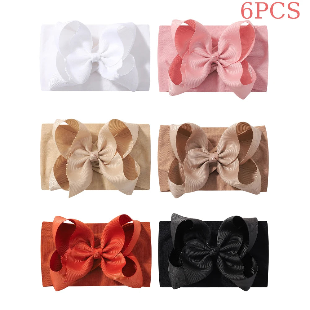 Six pairs of soft baby headbands with chunky hair bows in white, pink, beige, and orange colors.