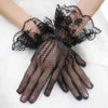Black sheer lace fishnet evening gloves worn on a hand.
