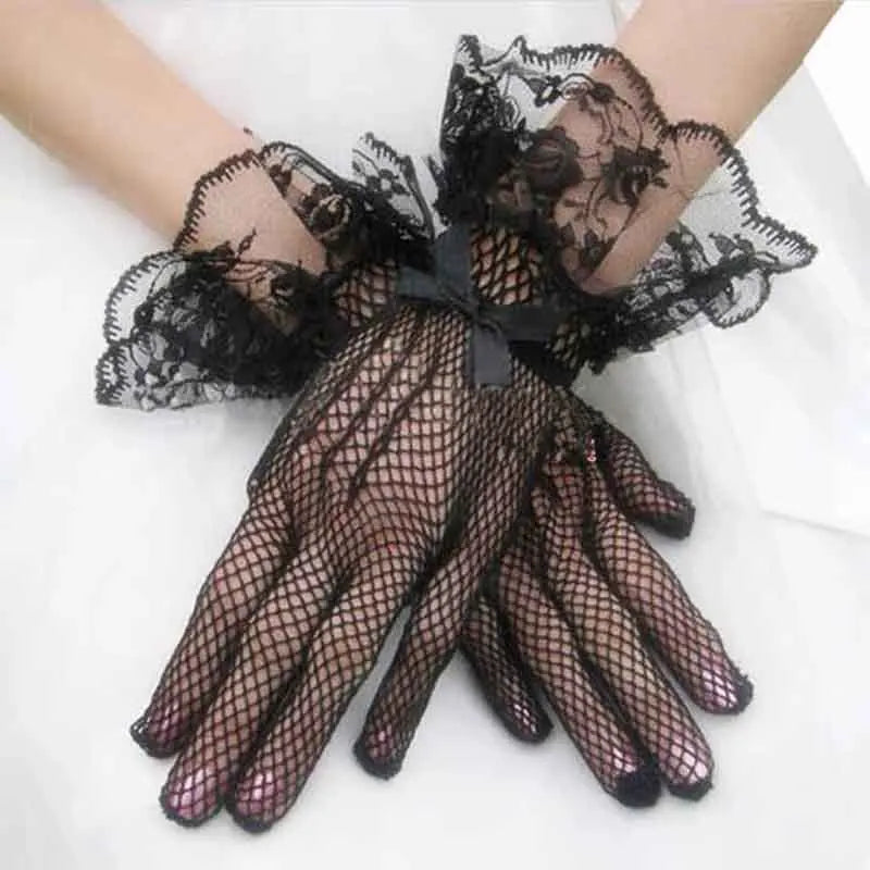 Black sheer lace fishnet evening gloves worn on a hand.