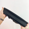 Une main tient un bonnet en dreadlocks noir, montrant sa conception flexible.