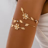 Gold floral vine arm bracelet worn on a person's wrist.