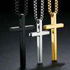 Three stainless steel cross pendant necklaces in black silver and gold displayed against a dark background