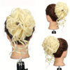 A display of synthetic blonde hair styled in a messy bun with long flowing strands.