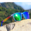 Blue and green gradient polarized sunglasses resting on a light-colored rock outdoors.