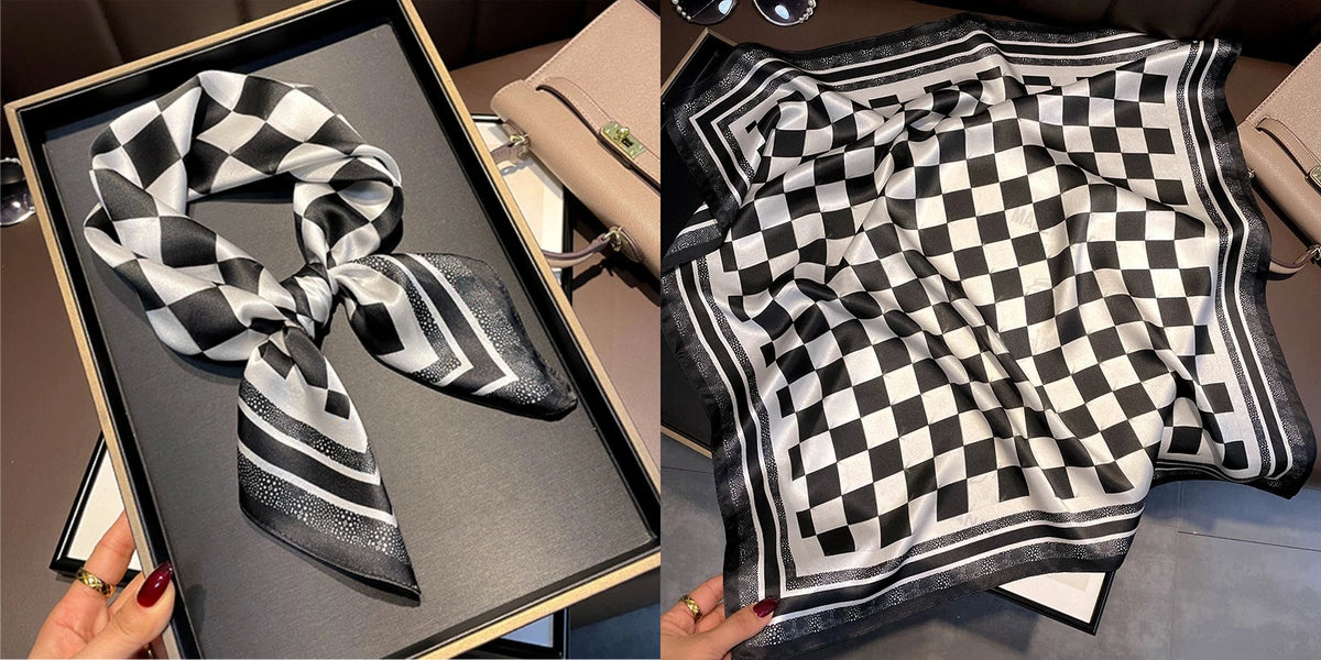 A black and white checkered silk scarf tied in a bow displayed in a box.