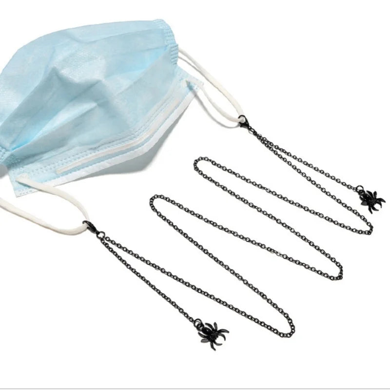 Light blue face mask with a black chain necklace featuring a spider charm