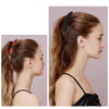 A woman's hair is styled with large banana hair clips, showing the clips and the finished hairstyle.