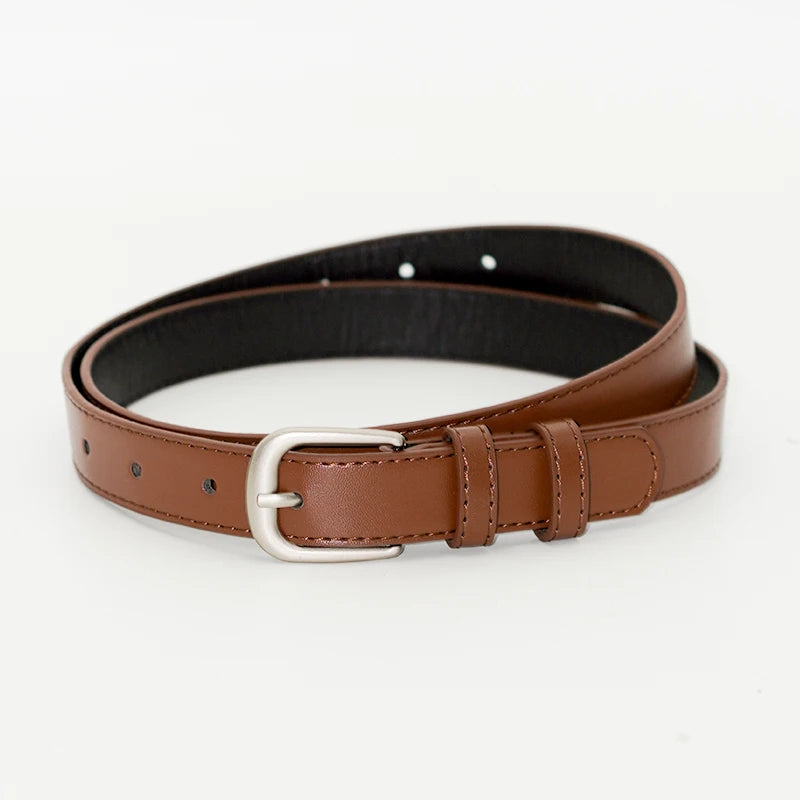 A brown leather belt with a silver buckle shown flat lay.
