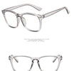 Une paire de lunettes claires et minimalistes avec des montures métalliques fines, montrées en studio.
