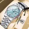 A silver-toned luxury quartz wristwatch with a light blue dial and metal bracelet resting on a beige surface.