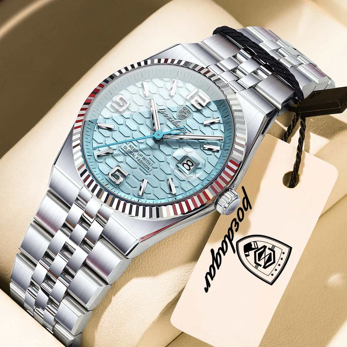 A silver-toned luxury quartz wristwatch with a light blue dial and metal bracelet resting on a beige surface.