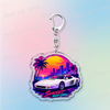 Silver pendant keychain featuring a silhouette of a sunset over a city skyline and palm trees.