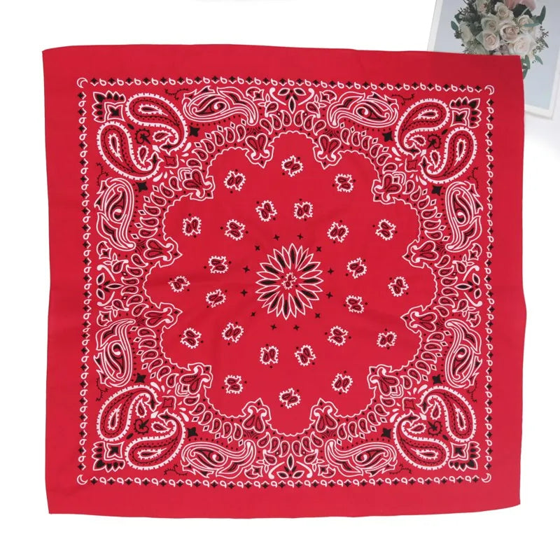 A red bandana scarf featuring intricate white paisley embroidery on a white background.