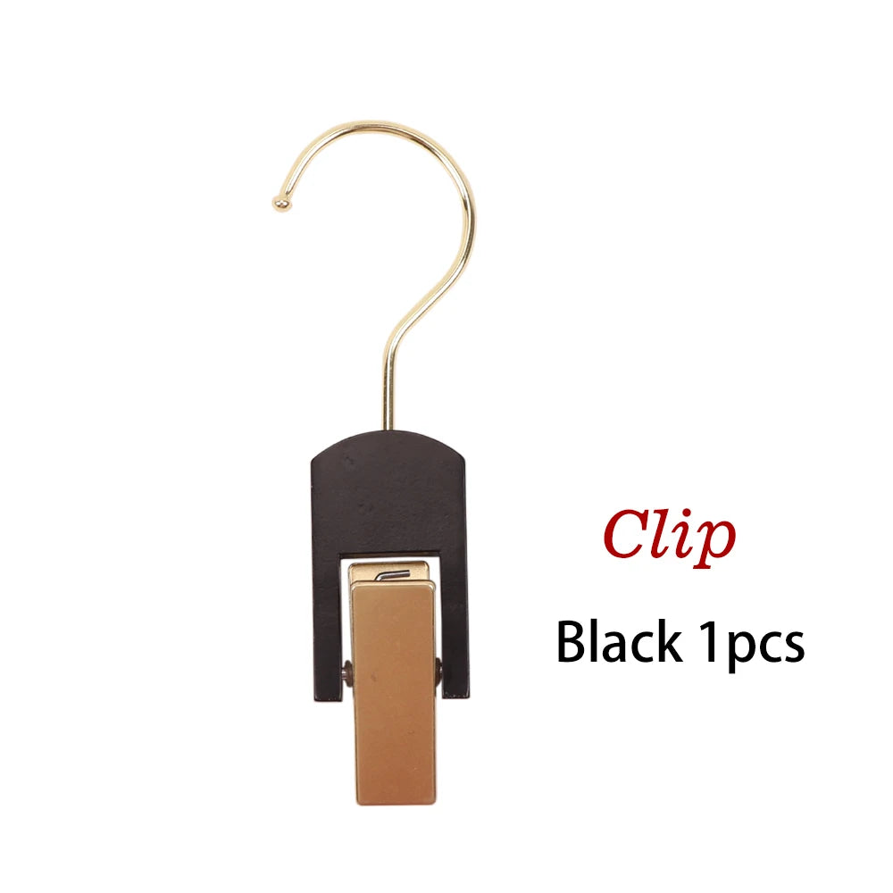 Black clip with a gold hook for holding wooden wigs and hair extensions