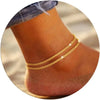 Gold plated glitter layered anklets worn on a foot.
