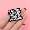 Una mano sostiene un pin de solapa esmaltado negro con el texto: Si crees que soy genial ahora, espera a ver mis hojas de cál