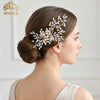 A close-up profile of a woman with brown hair styled in an updo adorned with a delicate white rhinestone bridal headband