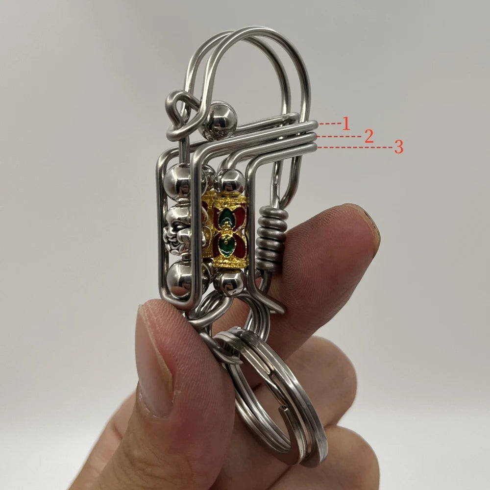 Une clé mécanique en acier inoxydable avec un charm décoratif est tenue dans une main.
