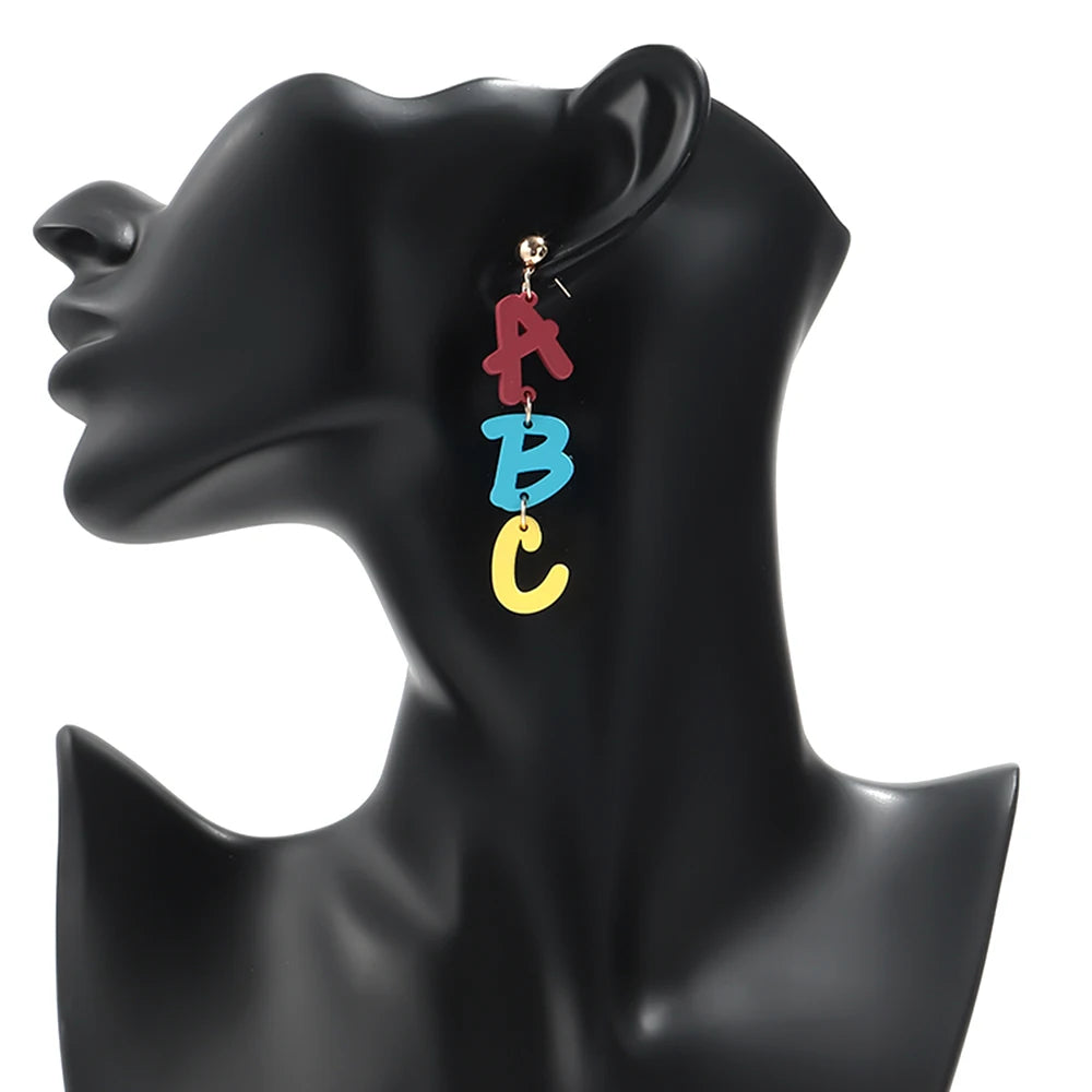 Pendientes colgantes con las letras A, B y C en esmalte rojo, azul y amarillo.