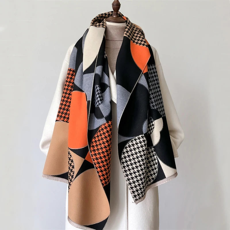 A luxury plaid cashmere feel scarf and shawl wrap featuring geometric patterns in black, orange, beige, and white.