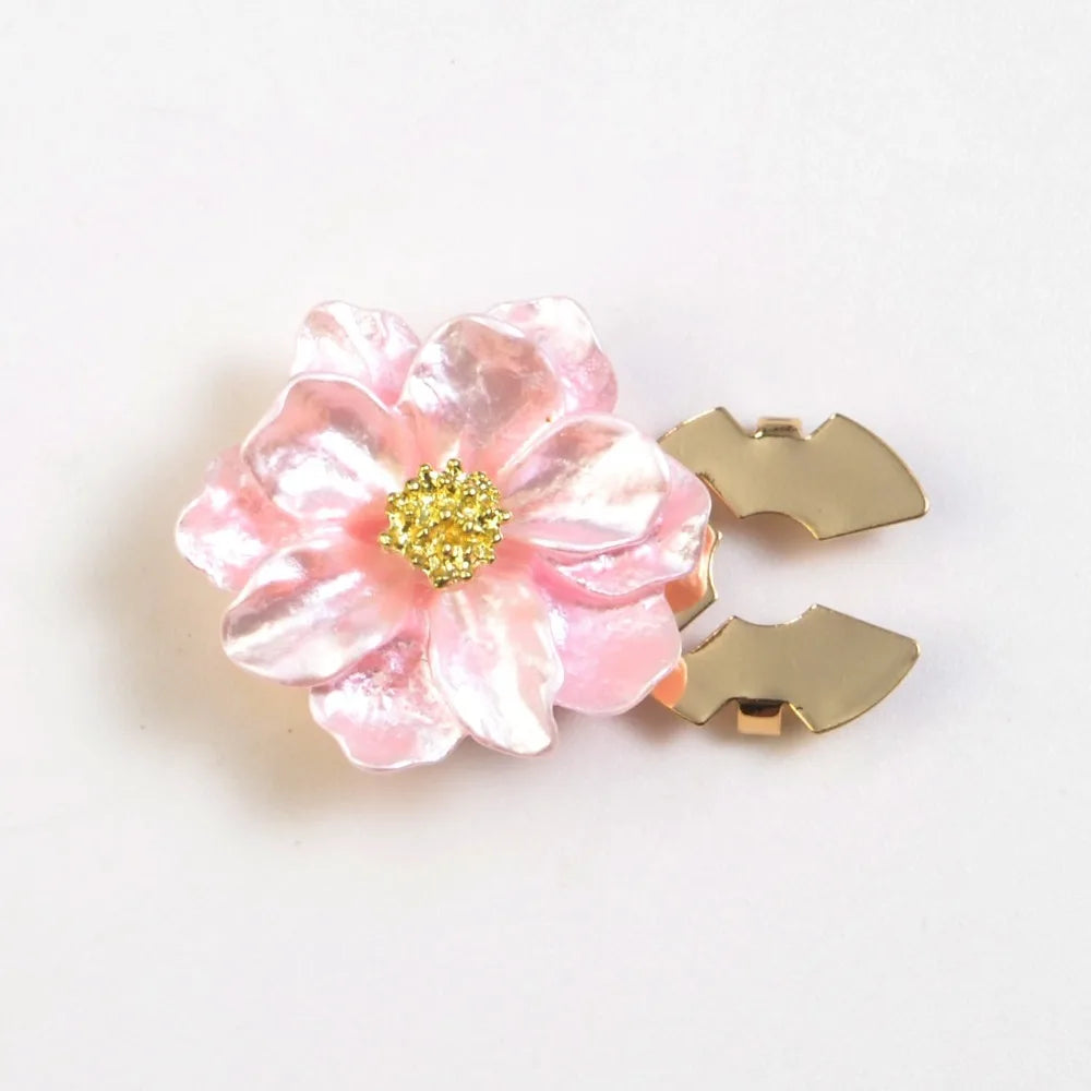 A pink, pearlescent flower button cover with a gold glitter center and two gold butterfly-shaped buttons.