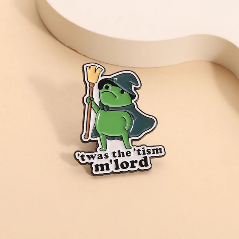 Insignia de esmalte con un mago rana verde sosteniendo un bastón y usando un sombrero puntiagudo