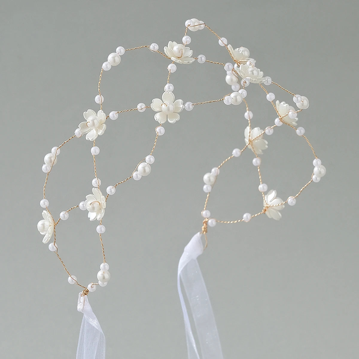 Elegant pearl hair net headband featuring small white floral embellishments