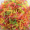 A pile of colorful disposable hair scrunchies in shades of orange, pink, yellow, and green.