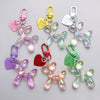 A collection of clear and colored resin animal dog keychains with heart charms and metal clasps.