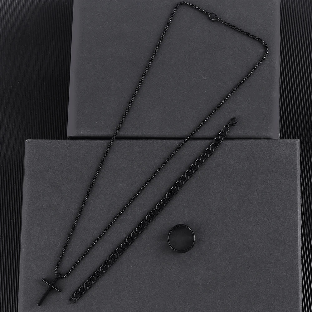 Un ensemble de colliers en croix en acier inoxydable pour hommes, présentés sur des boîtes gris foncé.