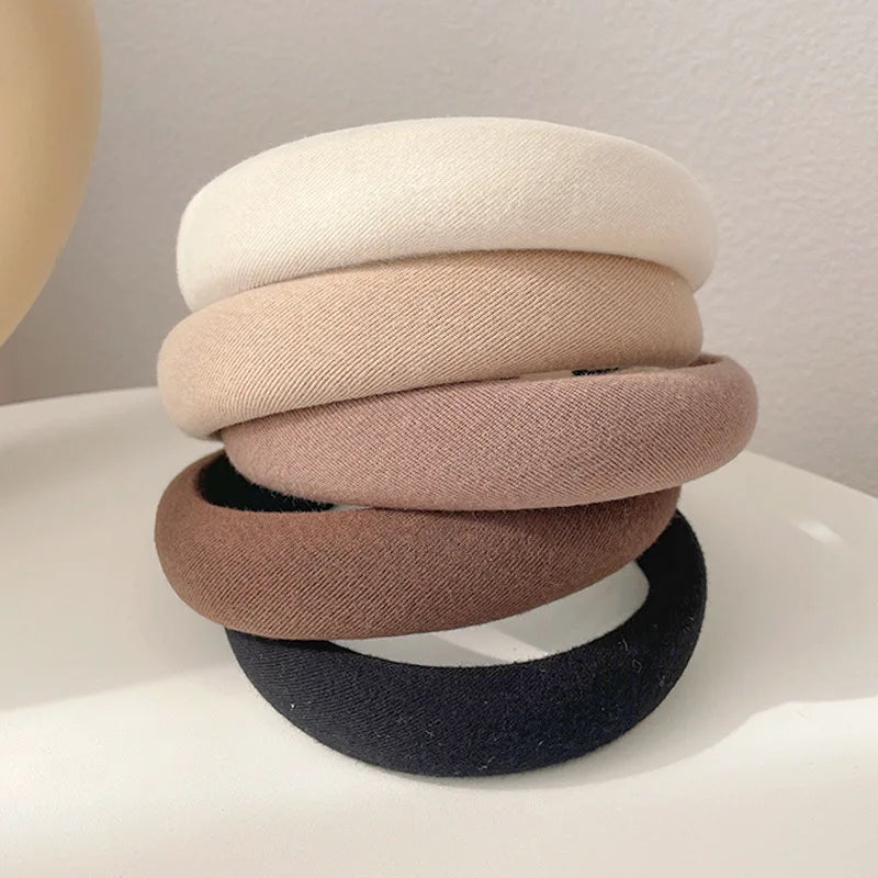 Pile de bandeaux pour cheveux épaissis de couleur café, dans diverses nuances de beige et brun.