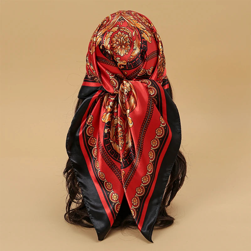 A red and black satin silk scarf tied around a woman's hair.