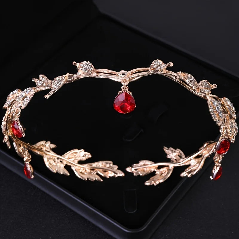 Tiare et couronne en strass de cristal baroque ton or, présentés sur une surface de velours noir.