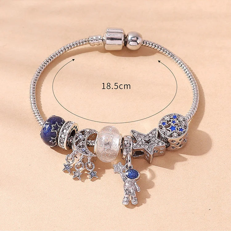 A silver beaded love bracelet set featuring various charms including a blue stone, a star, and other decorative elements.