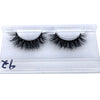 A pair of black mink false eyelashes displayed on a clear plastic tray.