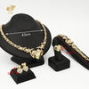 A set of 18K gold heart crystal jewelry including a necklace and earrings displayed on a black stand.