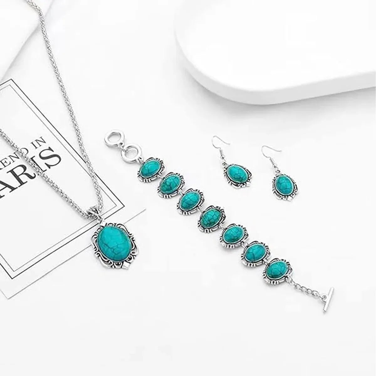 A set of vintage turquoise stone jewelry including a necklace, earrings, and bracelet displayed on a white background.